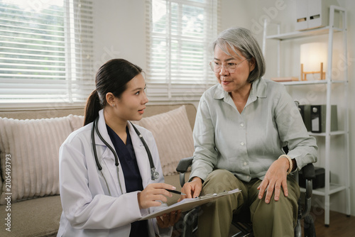 Quadro su tela Healthcare professional reviewing a care plan with a senior wheelchair user during a home healthcare visit, promoting personalized elderly support