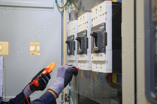 Fotografie Electricians use a meter to measure the current at the main breaker of the MDB cabinet to check the voltage