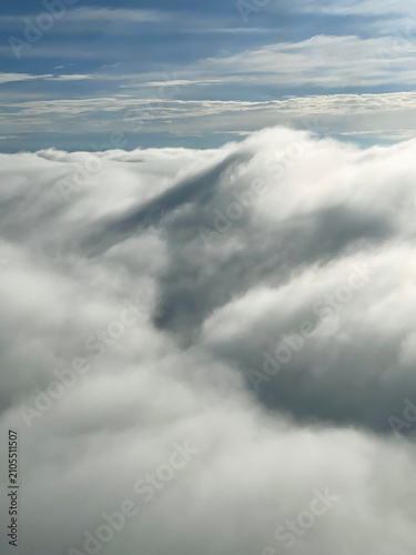 Fotografie Plane flying into dense cloud with soft blurred view from the window
