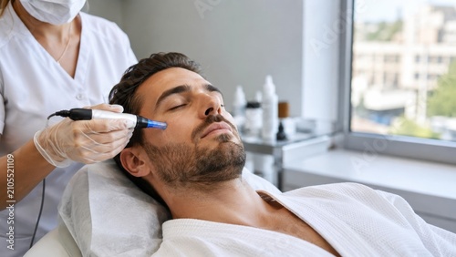 Man receiving microneedling facial treatment in professional clinic