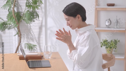 ノートパソコンを見て応援する女性