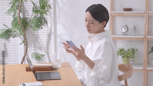 スマホと通帳を見る女性