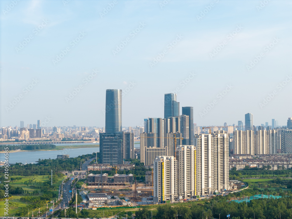 Fototapeta premium A panoramic aerial view of modern skyscrapers and urban architecture along the river in Nanchang City located in Jiangxi province of China during a clear day