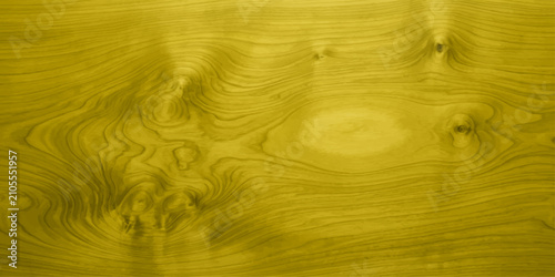 A close-up shot showcases the intricate grain patterns of a golden-hued wood surface, revealing natural textures and organic swirls.