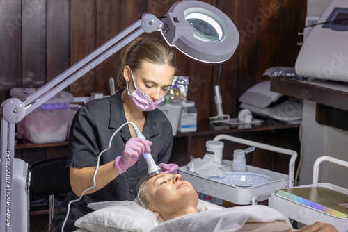 фотографія Cosmetologist performs a professional radio frequency facial treatment to improve skin firmness and rejuvenation using advanced aesthetic equipment in a modern beauty clinic