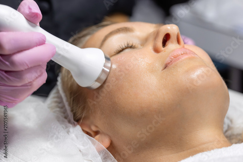 Tableau sur toile Close-up of a cosmetic physician performing radio frequency facial treatment to improve skin firmness, stimulate collagen production and rejuvenate the face in a beauty clinic