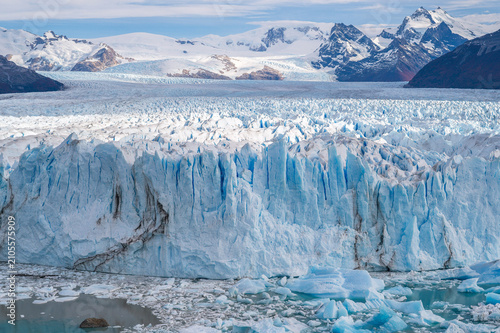 Perito moreno glacier wall demonstrates environmental concern as climate change affects massive ice formation showing majestic power and awe Patagonia nature during bright winter sunlight