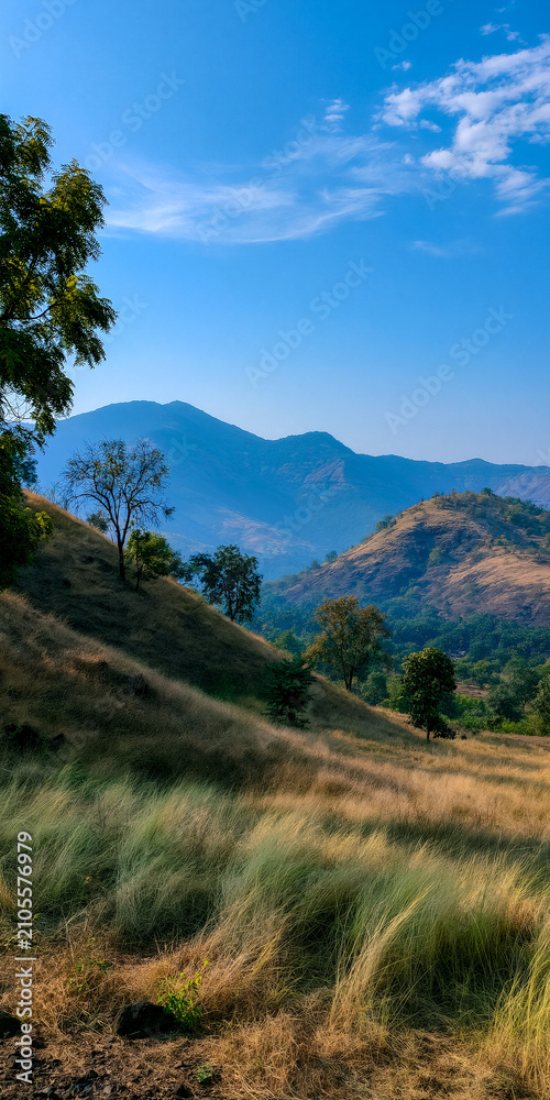 Fototapeta premium Scenic Landscape with Rolling Hills and Blue Sky: Breathtaking View of Nature's Beauty