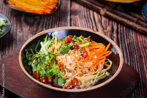 Foto Asian Cold Noodles with Vegetables and Spicy Sauce in Traditional Bowl