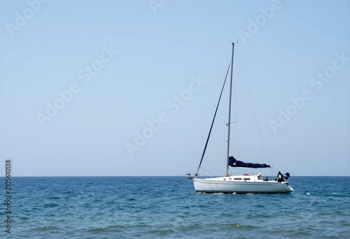 White sailboat with blue sa...