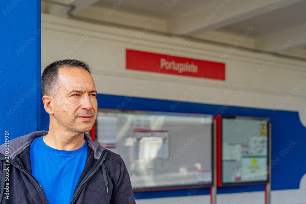 Fototapeta premium White European man in a blue shirt is landing at the Portugalete train station.