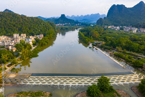 Fotografie Aerial view of river weir and karst mountains in Lipu, Guangxi, China