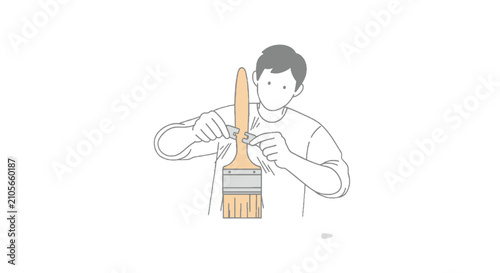 Person holding paintbrush with wooden handle and bristles.