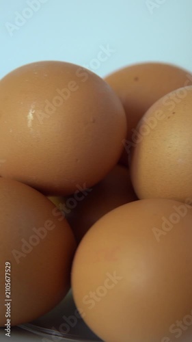 Brown eggs grouped on a surface. vertical video