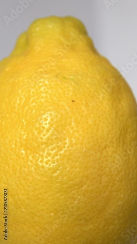 Close view of a lemon showing its skin texture. vertical video