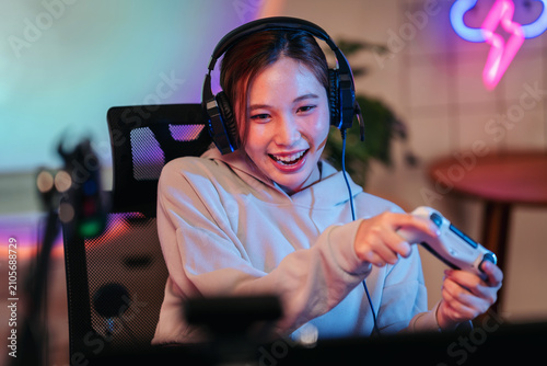 Excited young female gamer playing intense online video games we