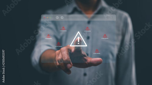A person interacts with a transparent digital interface displaying multiple warning alerts and an exclamation mark symbol.