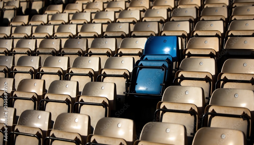 Fototapeta premium Showing pair of bright blue folding seats contrasting beige rows at open stand, with metal frames
