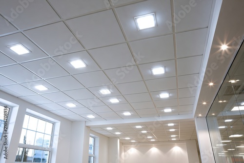 Bright, modern suspended ceiling with recessed square LED lights and windows