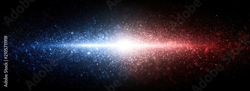 A bright, horizontal light burst splits into blue and red particles against black