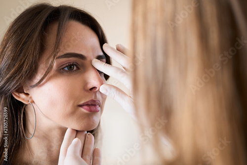 Foto Plastic surgeon examines female nasal septum to plan aesthetic beauty enhancement