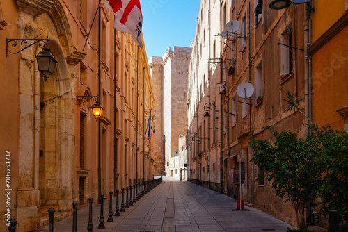 Narrow street in the historic Castello district of Cagliari with the Elephant Tower in the background, Sardinia, Italy