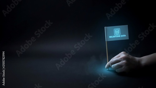 Human hand placing glowing milestone data flag symbolizing digital achievement