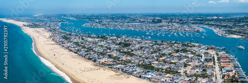 panoramic aerial landscape view of Balboa Peninsula with Balboa Beach in Newport Beach, California and with Lido Isle, Balboa Island, Harbor Island and Newport Beach cityscape in background 