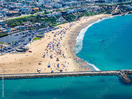 aerial landscape view of Corona del Mar State Beach, located in Corona del Mar, a seaside neighborhood in the city of Newport Beach, California with many people sunbathing at the beach and swimming