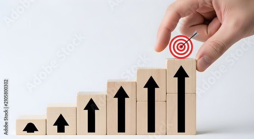 Hand Placing A Target Icon On Top Of Wooden Blocks Arranged As A Rising Growth Chart Representing Strategic Business Success And Career Achievement Goals
