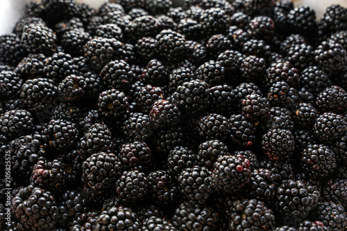 A high-angle, full-frame shot of fresh, ripe boysenberries packed closely together. The deep purple and black berries create a rich, textured natural pattern suitable for backgrounds and food concepts