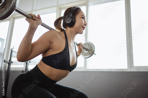Foto squat barbell training strength athlete Asian woman performing a barbell squat w