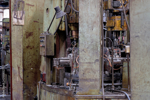 Obraz na plátně Industrial multi spindle drilling equipment coated with metal shavings and cutting fluid in a manufacturing workshop