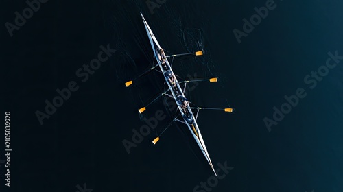 Aerial view of a rowing crew in a sleek boat gliding across dark water