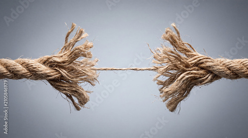A thick rope is frayed and breaking, symbolizing stress, failure, or reaching a limit.