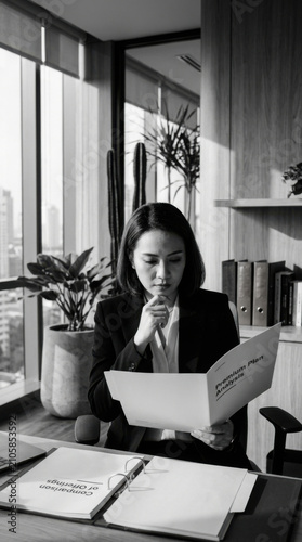 Focused Businesswoman Studying Documents In Modern Office Environment