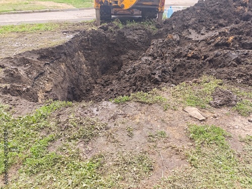 Cuadro en lienzo Deep earthen pit and a large pile of excavated soil on a lawn during municipal utility repair works