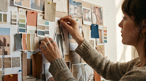 Female fashion designer pinning sketches and color swatches on mood board
