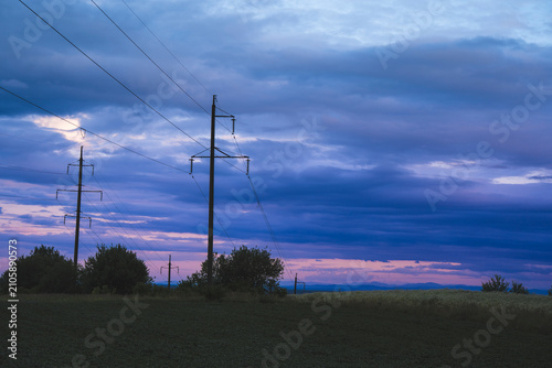 Foto High Voltage Power Line Poles and Wires Stretching Into Distance Across Rural Fi