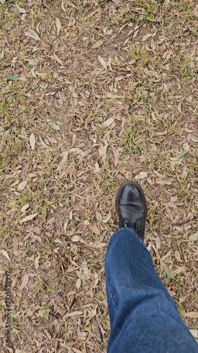 Vista POV de persona caminando sobre pasto seco y hojas