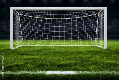 A soccer goal on a green field at night