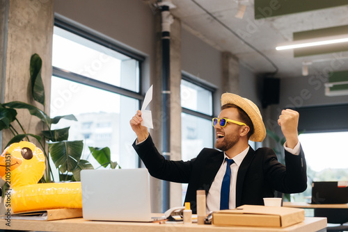 Fotografie Businessman celebrating success envisioning summer vacation