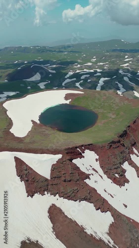 Vertical Video of Scenic Volcanic Crater Pond with Turquoise Water and Patchy Snow
