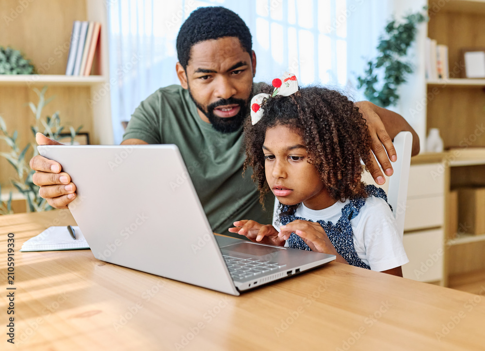 Obraz premium Father and daughter doing homework with laptop at home. Father and teenage girl happy using laptop. Teen girl and dad sitting at home working with notebook
