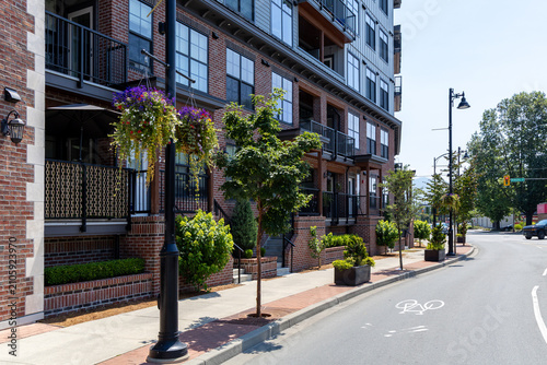 Photos Urban Brick Apartment Building With Balconies, Hanging Flower Baskets and Street