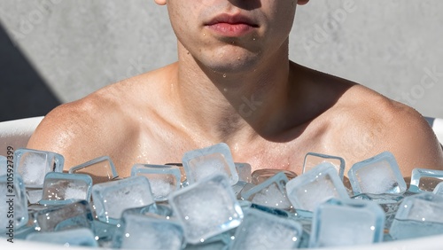 151. [STYLE] of an ice bath moment of resolve showing shoulders and clenched jaw above floating ice cubes with goosebump skin and frosted-tub textures, stark high-contrast daylight, glacial blue and f