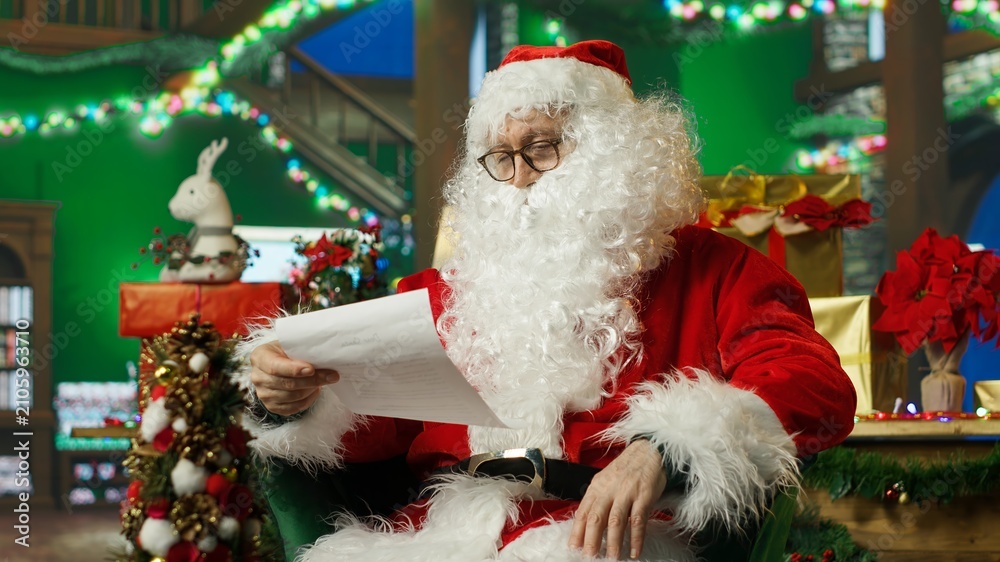Fototapeta premium Tired Santa Claus falls asleep while making the naughty-or-nice list before traveling around the world to deliver Christmas gifts to children.
