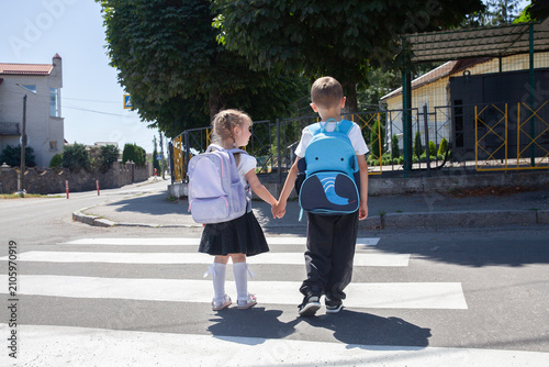 Brother and Sister Crossing the Street Together on Their Way to School