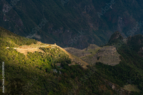 Sunlit agricultural terraces at Intipata archaeological site surrounded by forested Andean mountains along the Inca Trail to Machu Picchu, Peru