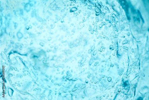Abstract light blue gel texture with bubbles. Clear cosmetic liquid smudge smear background. Hydrating hyaluronic acid skincare product macro backdrop. Serum cream stabilizer moisturizer consistency.